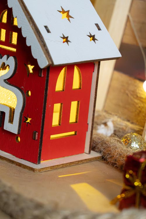 Rotes Adventshaus aus Holz mit Hirsch