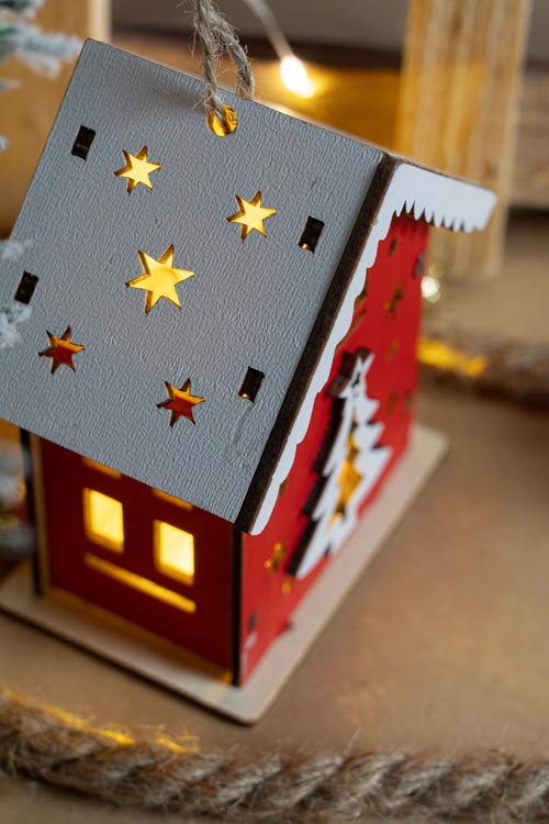 Rotes Adventshaus aus Holz mit Weihnachtsbaum