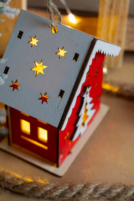 Rotes Adventshaus aus Holz mit Weihnachtsbaum